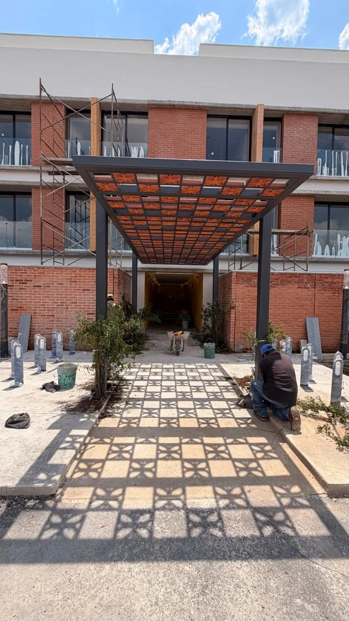 Pérgola de celosía de barro sobre el andador de acceso a la Torre 1